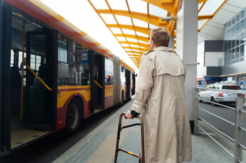 person in a coat holding a suitcase and stands near intercity bus