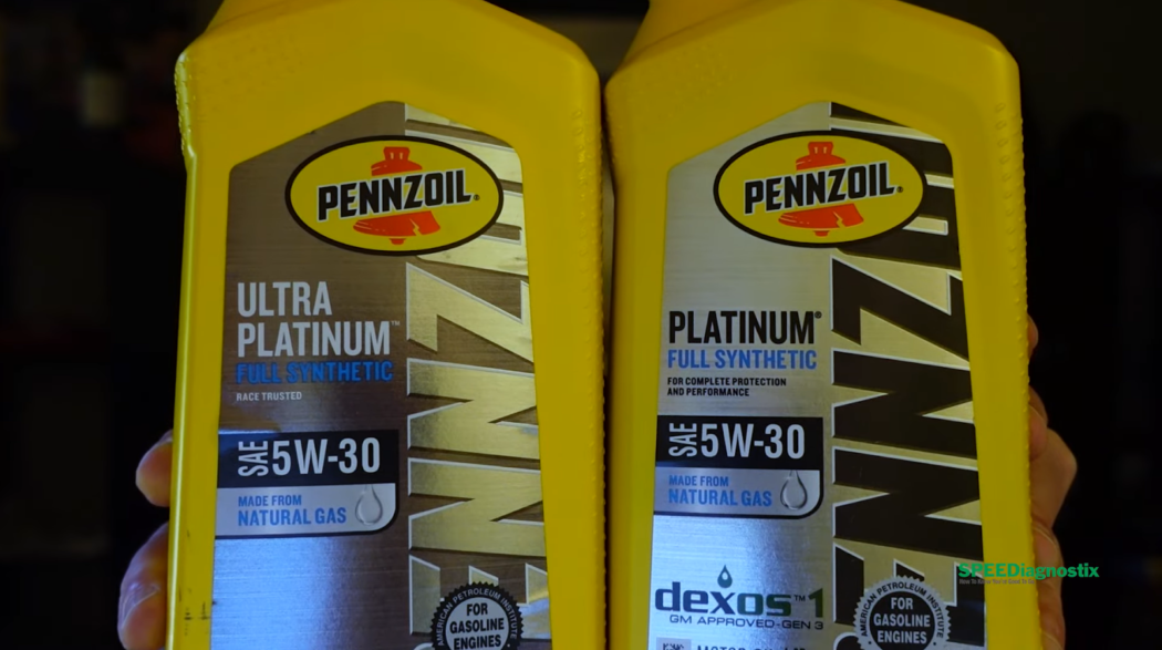 hands holding  two yellow bottles of Pennzoil Platinum