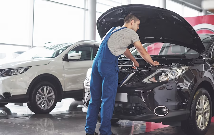 Man in jumper examining an open car hood