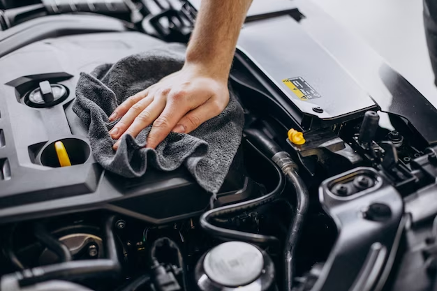 Person cleaning a car engine