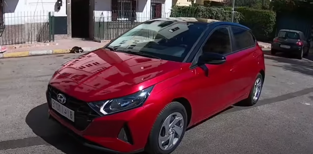 Side view of a red Hyundai i20 car outdoors