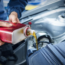 Hand adding oil to a car engine