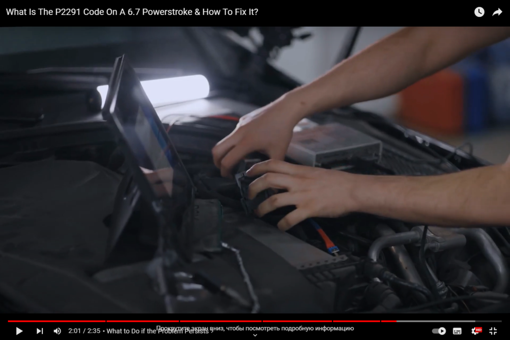 Male mechanic fixes an engine error by connecting a computer to it